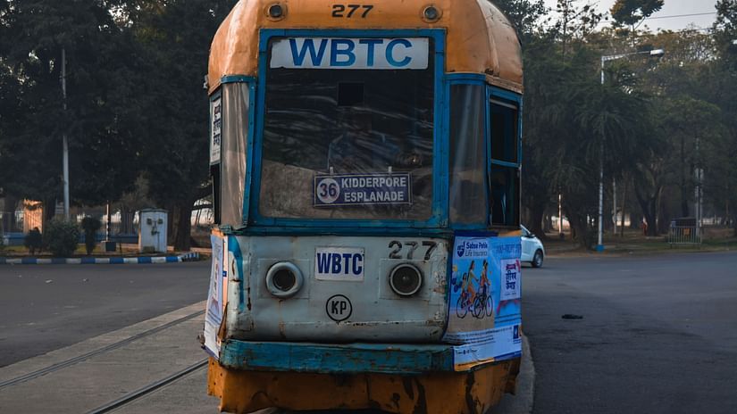 an overview of a yellow coloured tram in kolkata on the road