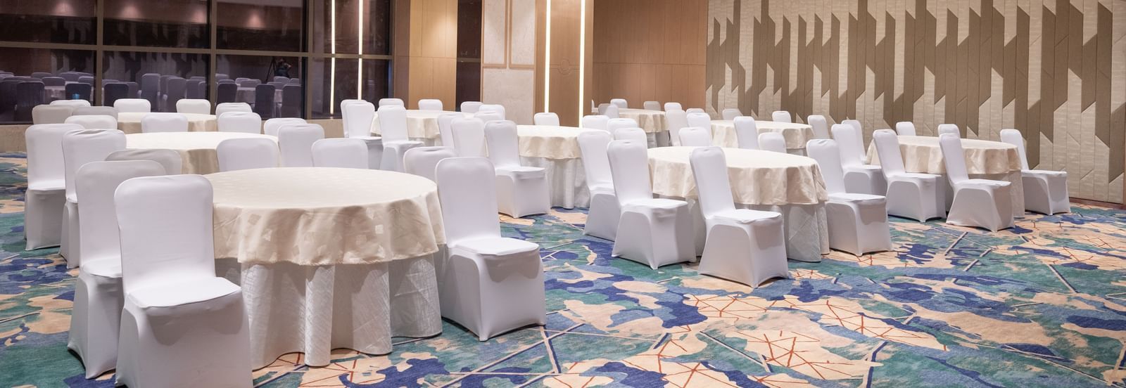 Spacious room with banquet-style seating and warm lighting at Merlis Hotel, Coimbatore.