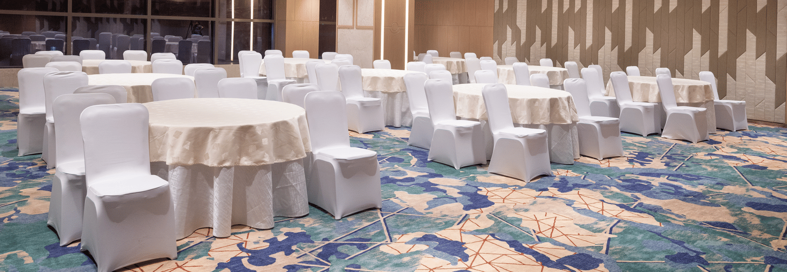 Spacious room with banquet-style seating and warm lighting at Merlis Hotel, Coimbatore.