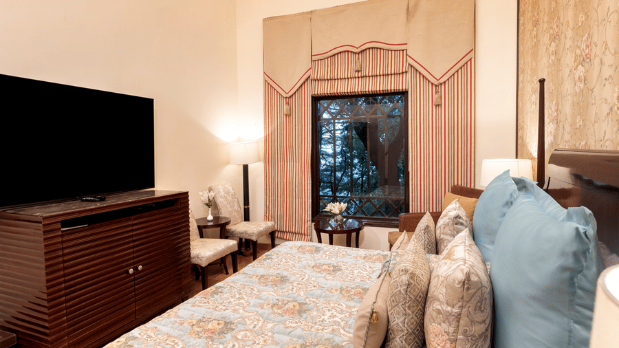 image of the Duplex Family suite with a TV and a window with outside view at The Claridges Nabha Residence