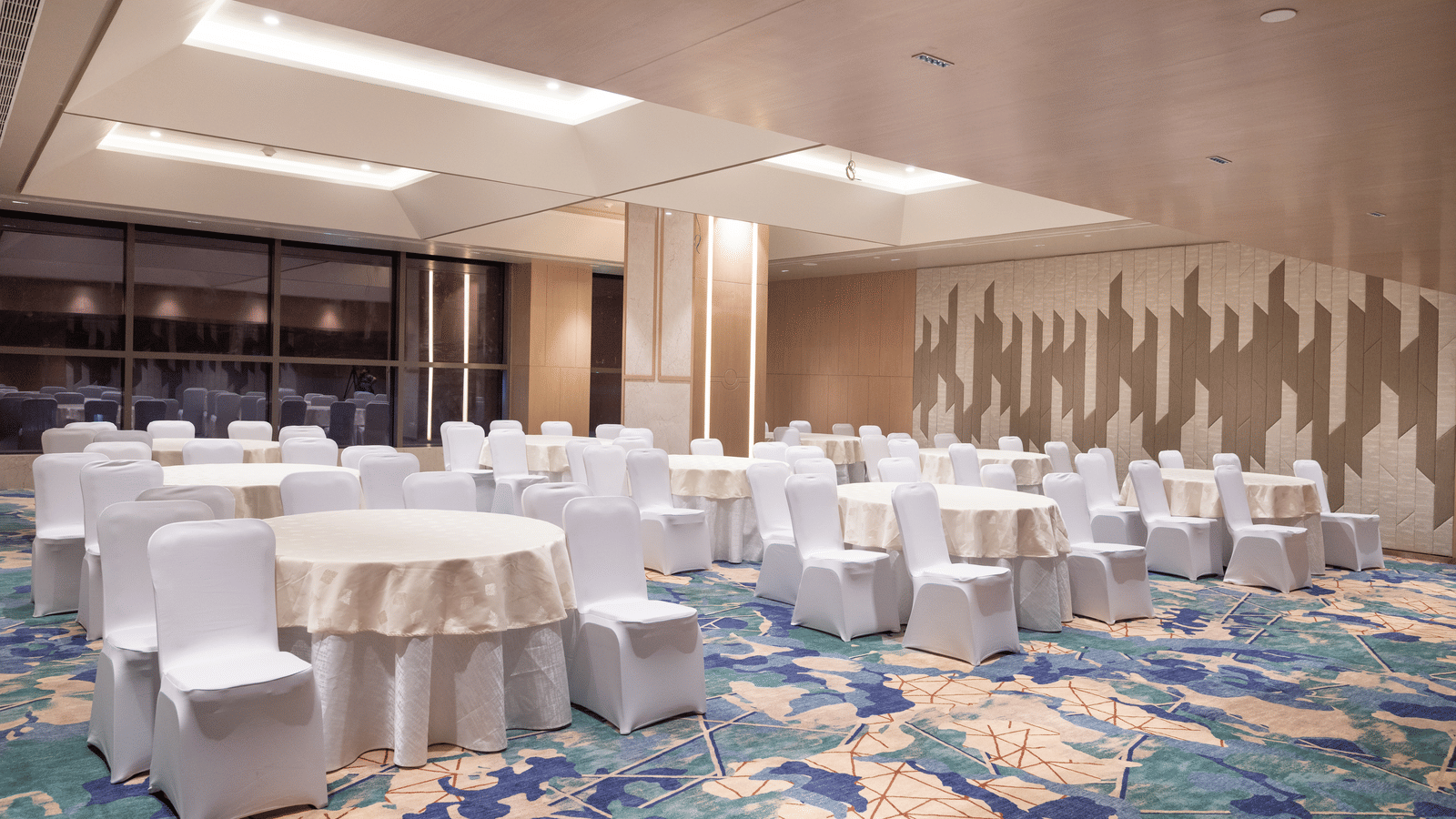 Spacious room with banquet-style seating and warm lighting at Merlis Hotel, Coimbatore.