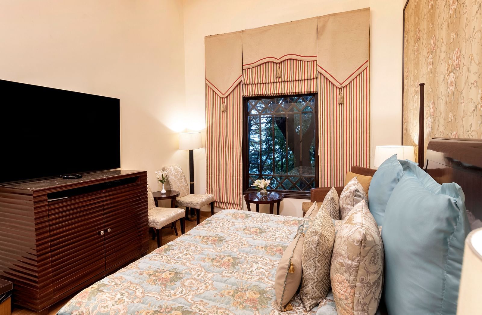 image of the Duplex Family suite with a TV and a window with outside view at The Claridges Nabha Residence
