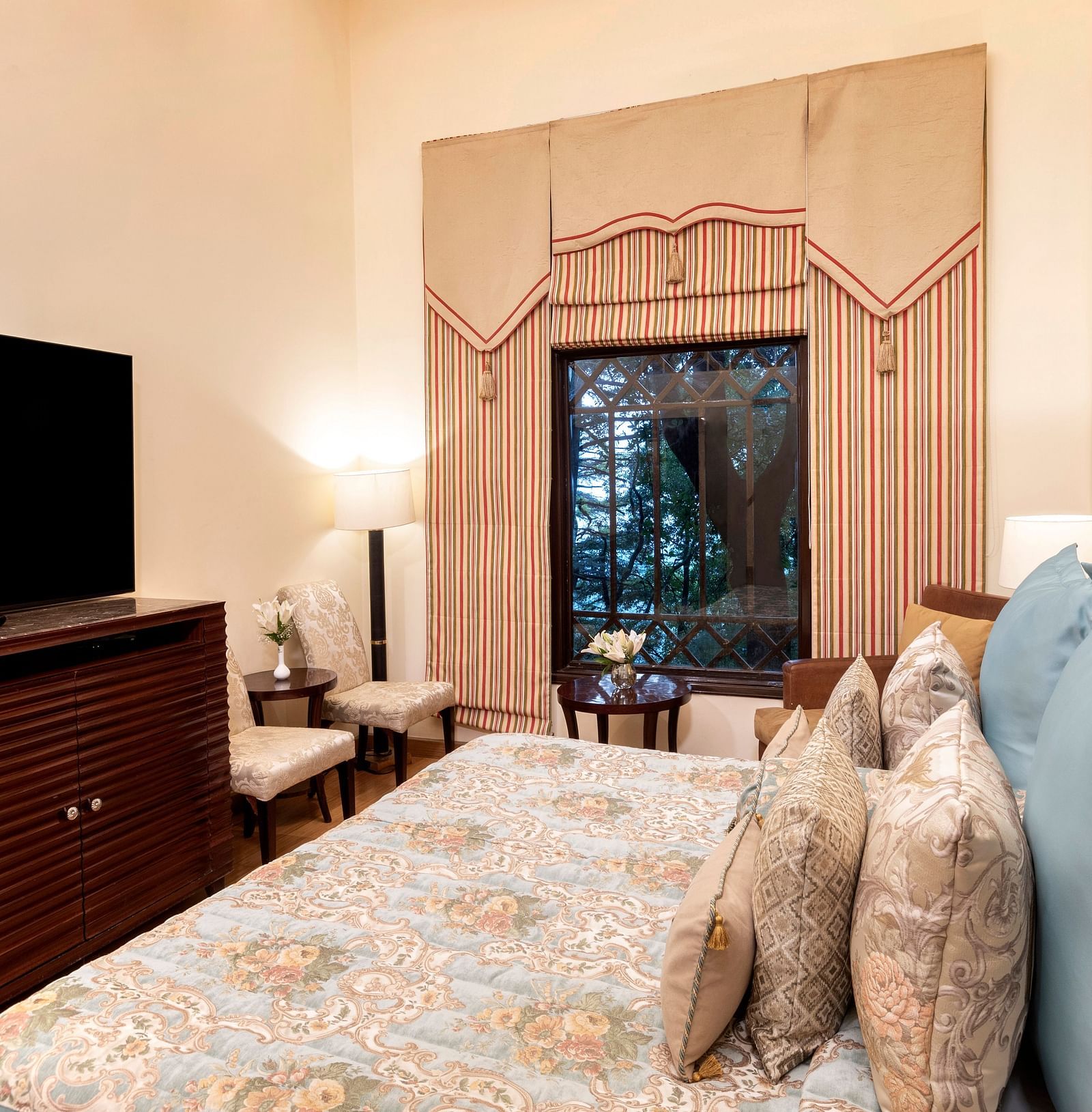 image of the Duplex Family suite with a TV and a window with outside view at The Claridges Nabha Residence