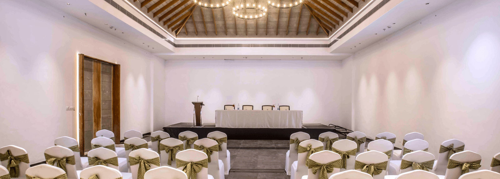 An image of the banquet hall in Wayanad with seating arrangement and a chandelier | Great Trails Wayanad by  GRT hotels.