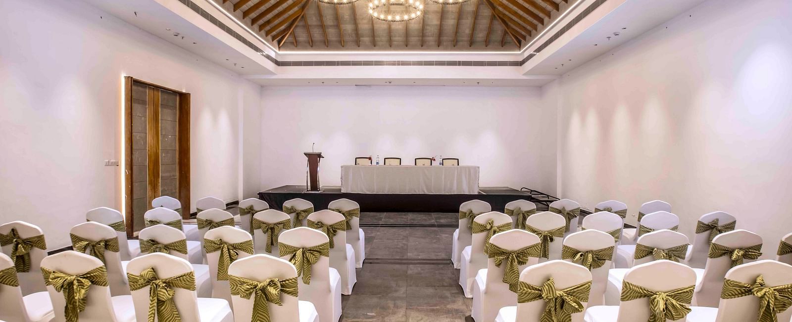 An image of the banquet hall in Wayanad with seating arrangement and a chandelier | Great Trails Wayanad by  GRT hotels.