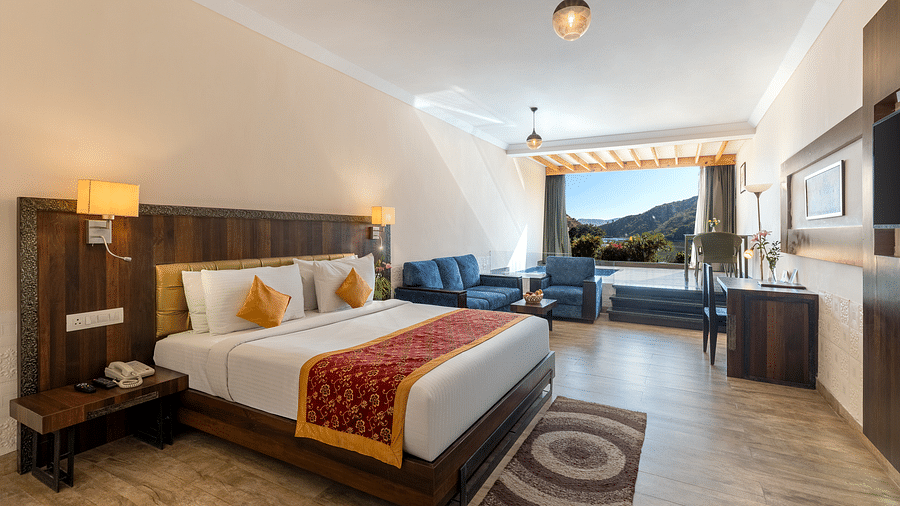A bedroom neatly arranged with a made bed, a patterned runner on it and a lamp on the ceiling - Via Lakhela Resort & Spa