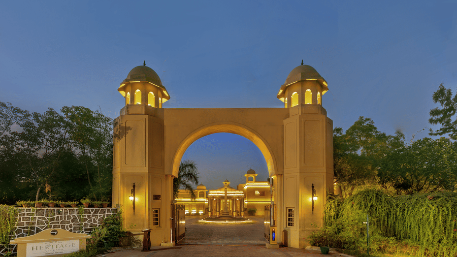 An arched, well-lit getaway of Heritage Village Resorts and Spa, Manesar, during evening