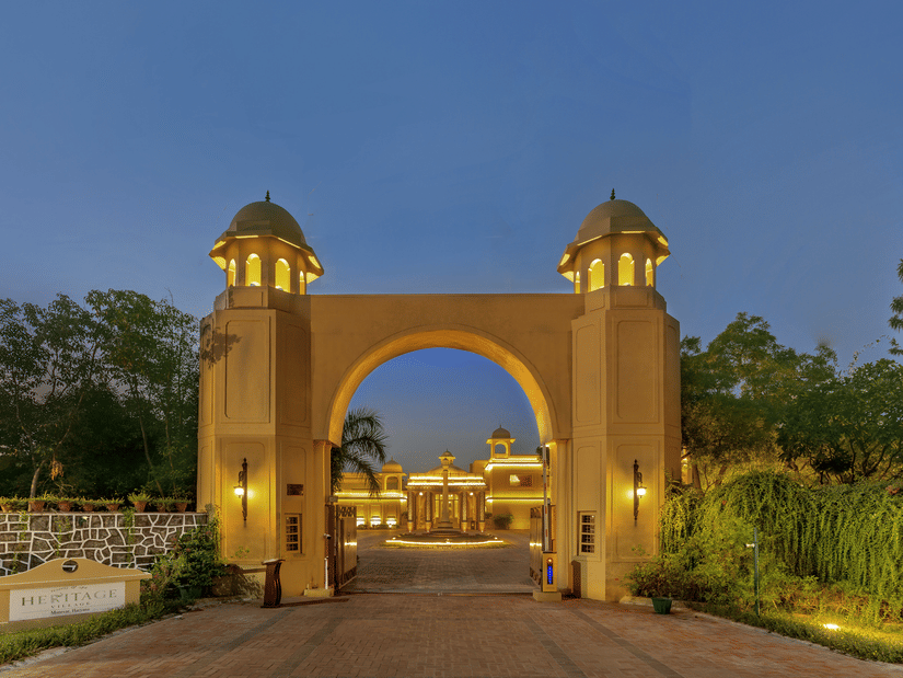 An arched, well-lit getaway of Heritage Village Resorts and Spa, Manesar, during evening