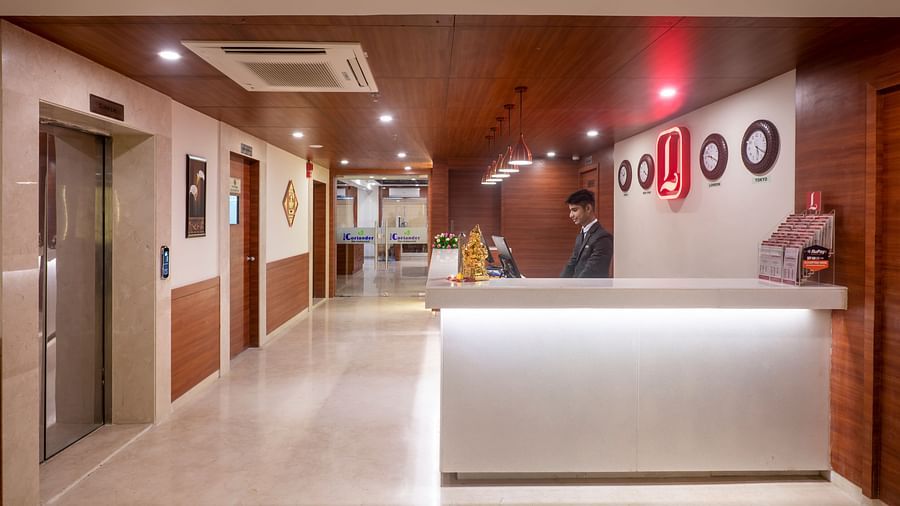 Hotel lobby with front desk and well-lit corridor leading to guest rooms - Lords Eco Inn Shapar Rajkot