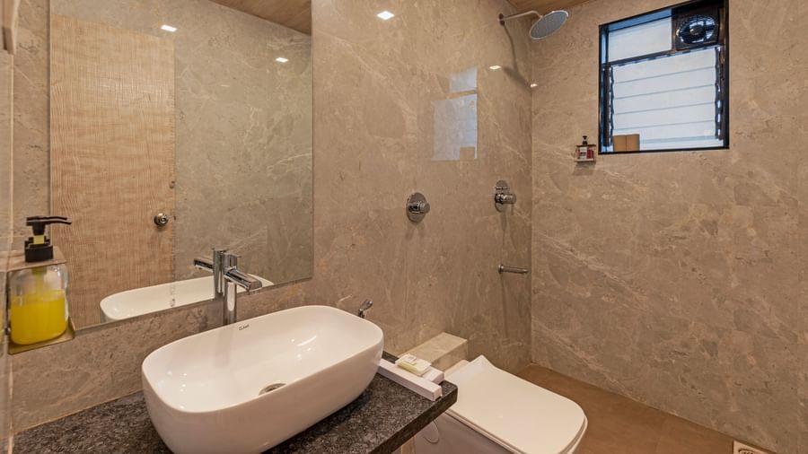Modern bathroom at Emerald Retreat, Tungarli with stylish beige tiling, a rain shower, and contemporary fittings.