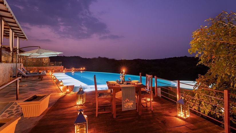 A view of the swimming pool with a table for two set up next to it - Chunda Shikar Oudi, Udaipur