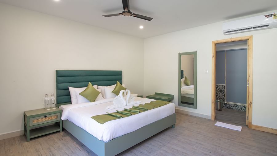 Spacious and well-lit hotel room with a large double bed and en-suite bathroom. | Stone Wood Jungle Resort, Dandeli