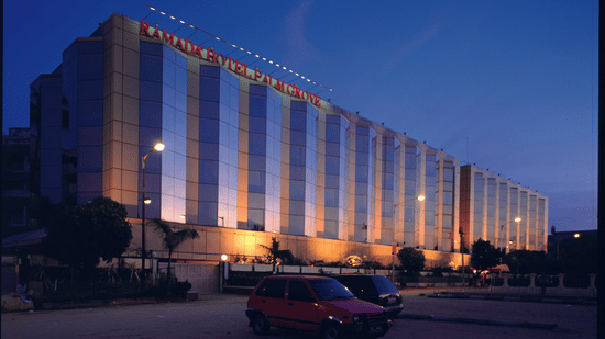 Facade view during twilight with the lights on and signage lit - Hotel Ramada Plaza Palm Groveduring twilight with the lights on and signage lit - Hotel Ramada Plaza Palm Grove
