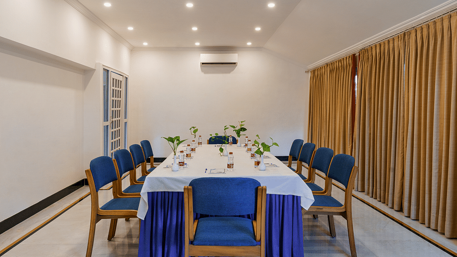 An overview of raj darshan conference hall in Udaipur with a large table and blue chairs in view - Hotel Rajdarshan, Udaipur.