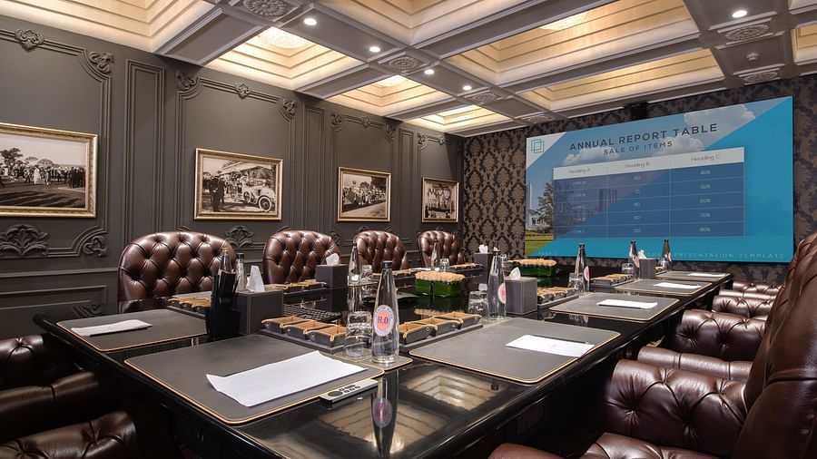 a wide screen television wall mounted at the far end of the king george V board room - The Claridges New Delhi