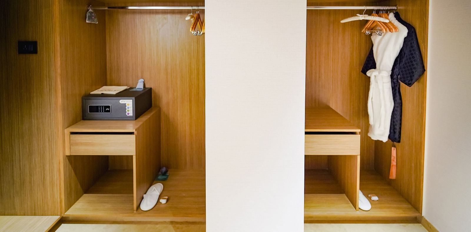 A walk-in wardrobe in our hotel room with a in-room safe and bath robes