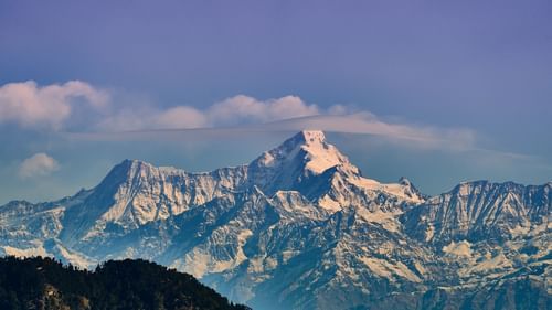 snow-capped mountains during day time with a lavender blue sky in the background