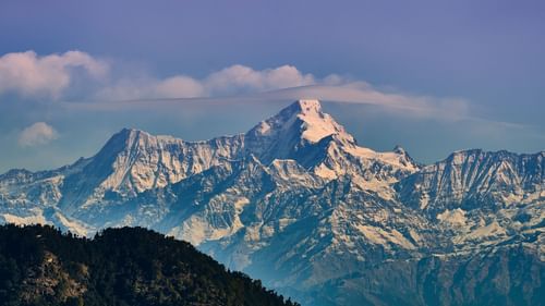 snow-capped mountains during day time with a lavender blue sky in the background