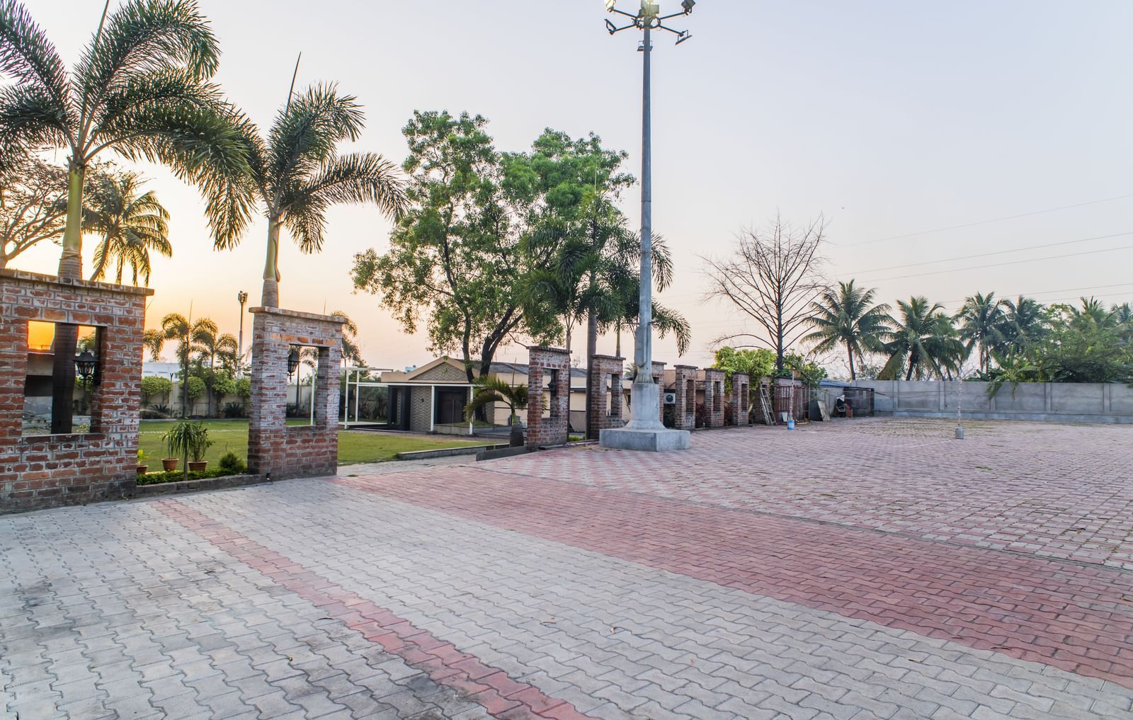 The exterior grounds of The Citi Residenci Hotel, Asansol, with palm trees and lighting.