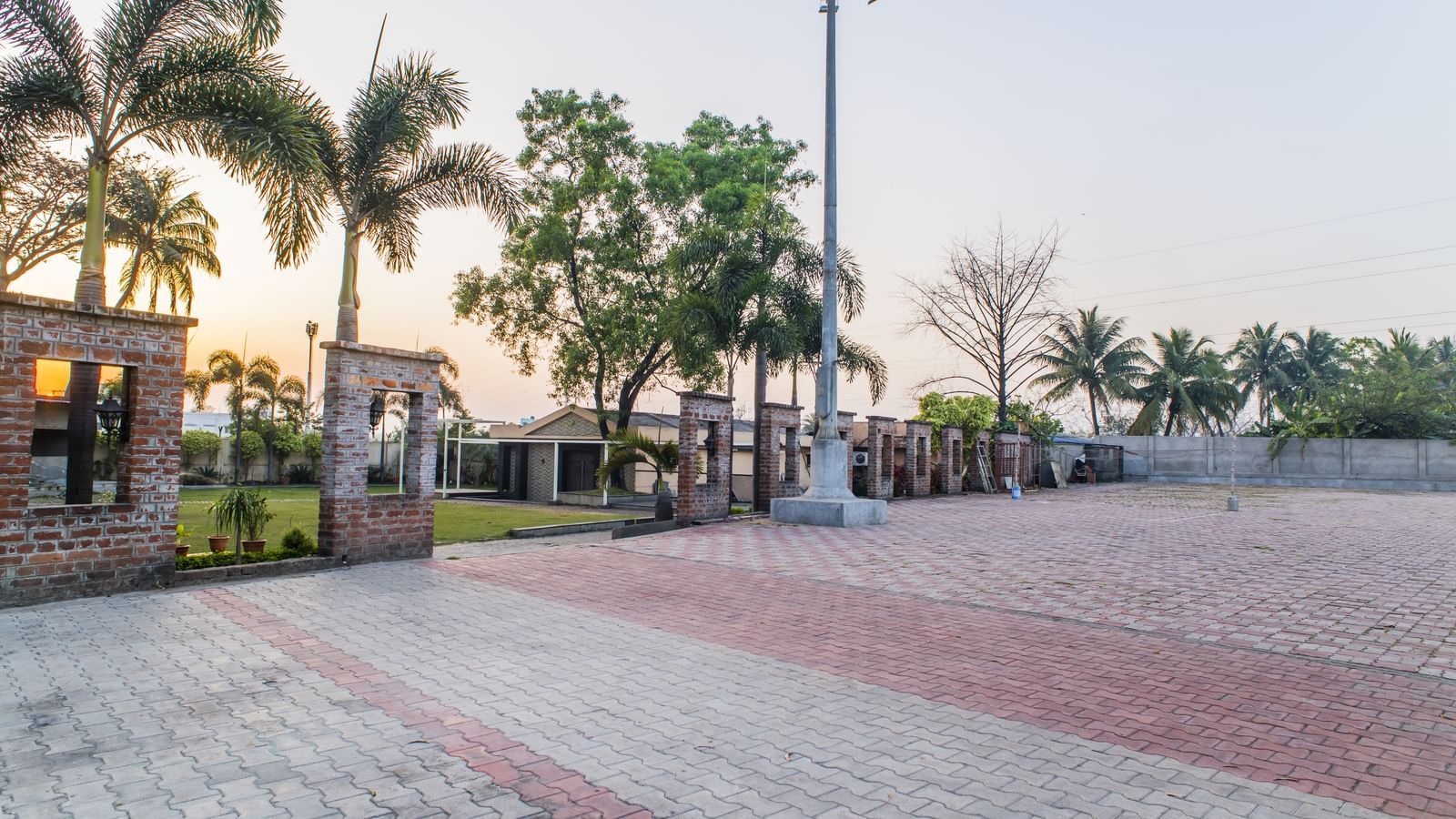 The exterior grounds of The Citi Residenci Hotel, Asansol, with palm trees and lighting.