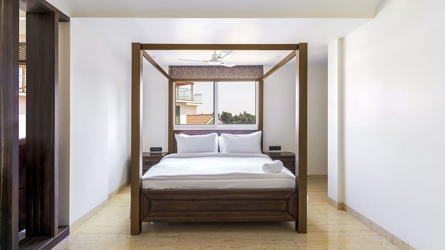 A double bed with wooden beams inside one of the rooms - The Tanisi Hotels & Resorts, Goa