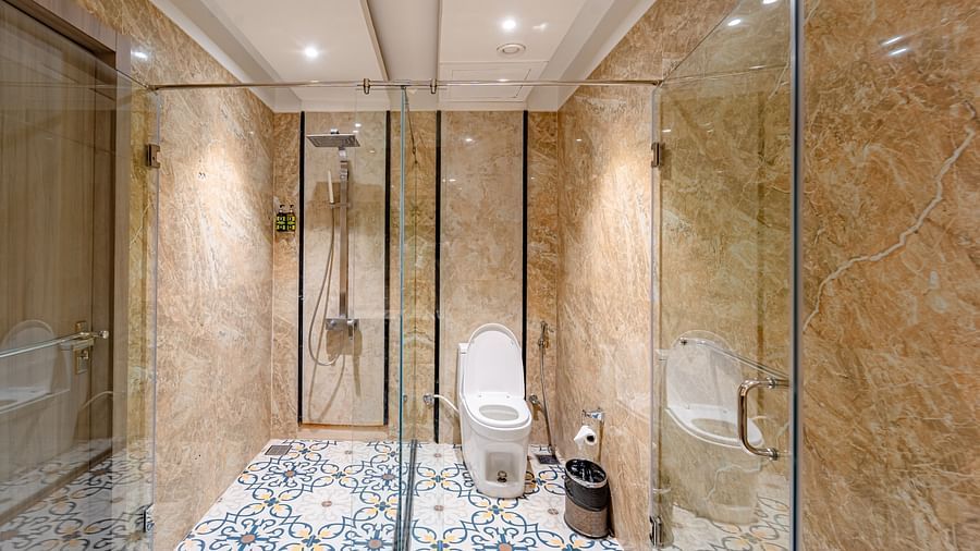 Family Room bathroom features a glass partition separating the shower area from the western toilet seating at Crescent Spa & Resort, Indore