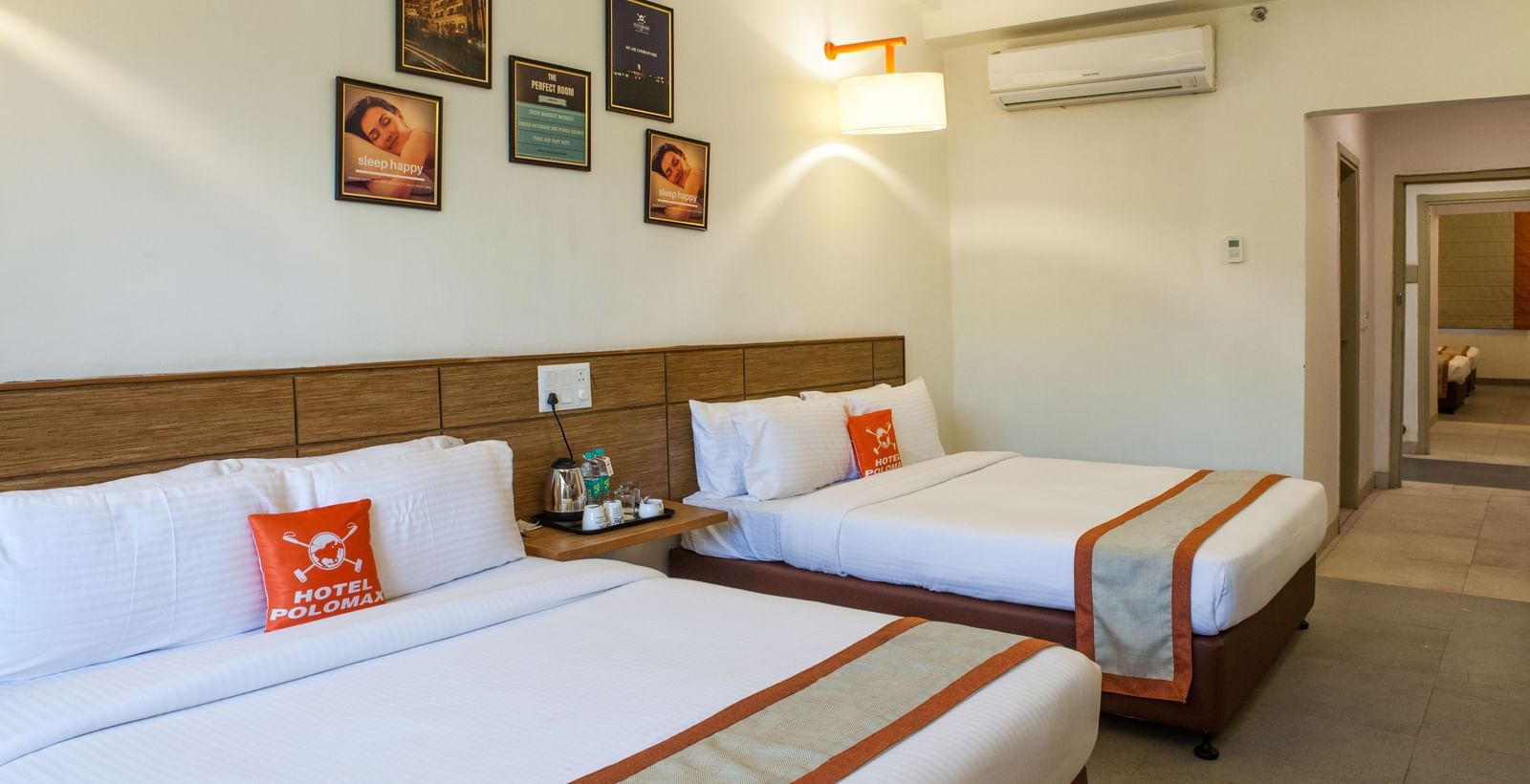 Elegant room with two double beds, wall decor and bright lightiing.