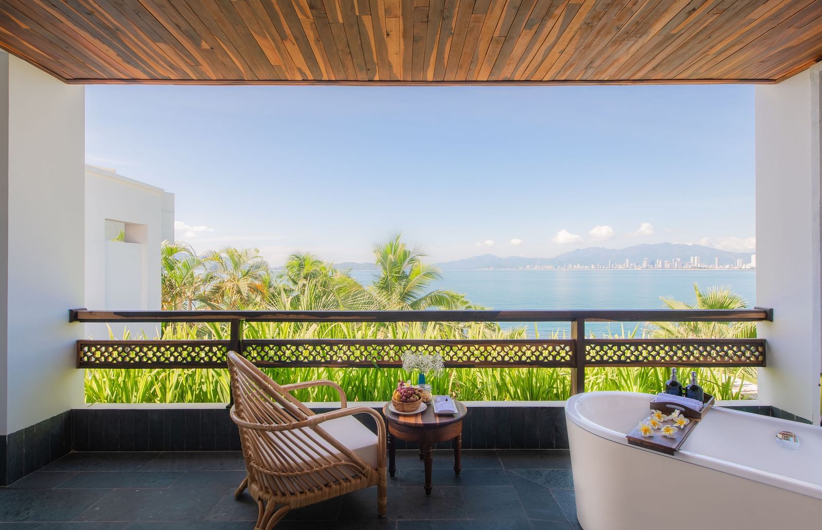 A balcony at one of our resorts with a wooden chair to relax and a bathtub to take a bathtub watching the stars - Alibu Resirt Nha Trang