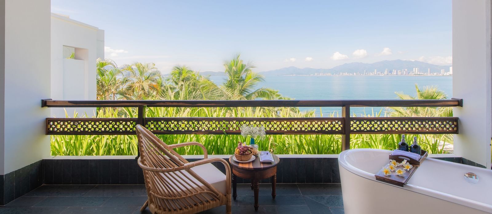 A balcony at one of our resorts with a wooden chair to relax and a bathtub to take a bathtub watching the stars - Alibu Resirt Nha Trang