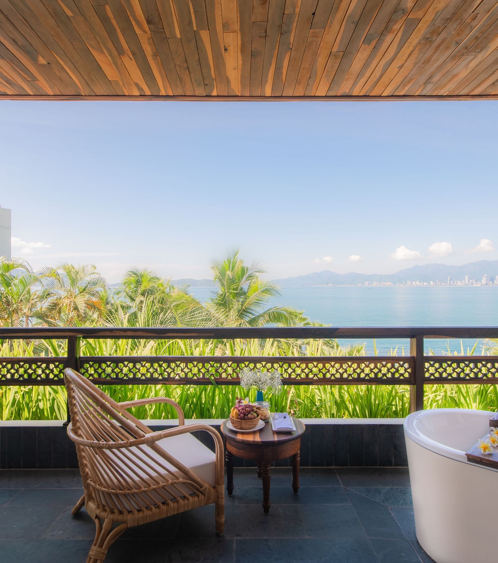 A balcony at one of our resorts with a wooden chair to relax and a bathtub to take a bathtub watching the stars - Alibu Resirt Nha Trang