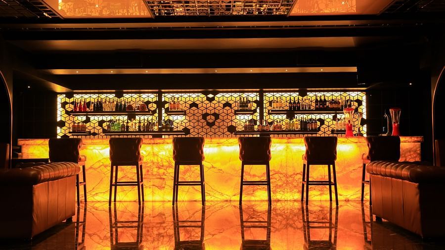a close up shot of the Bar Counter with a showcase in the background at Alchemy, our in-house bar in Chennai - Raj Park Hotel, Chennai