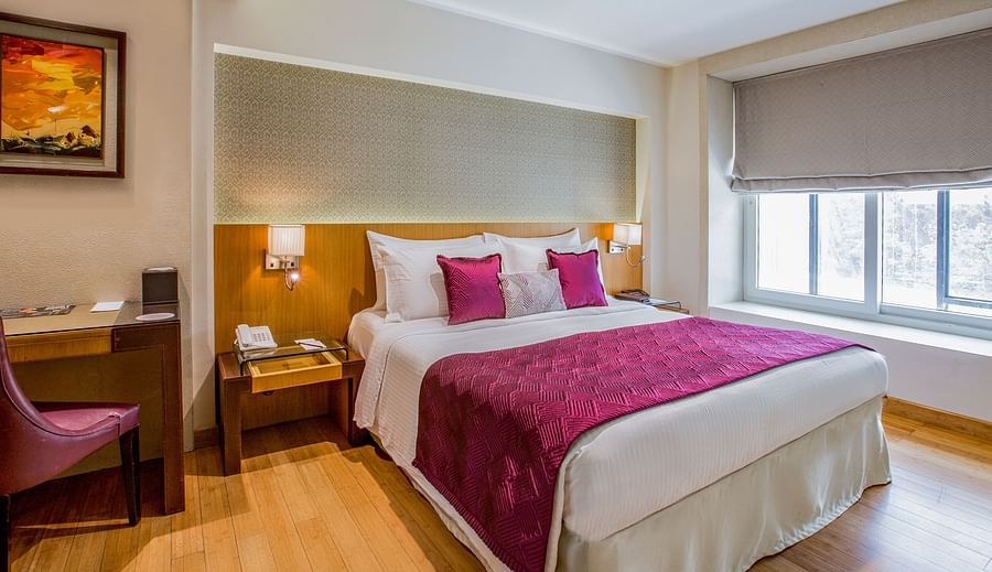 room with king size bed and wooden flooring at hotel bawa continental