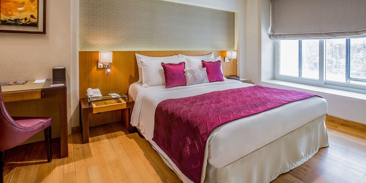 room with king size bed and wooden flooring at hotel bawa continental