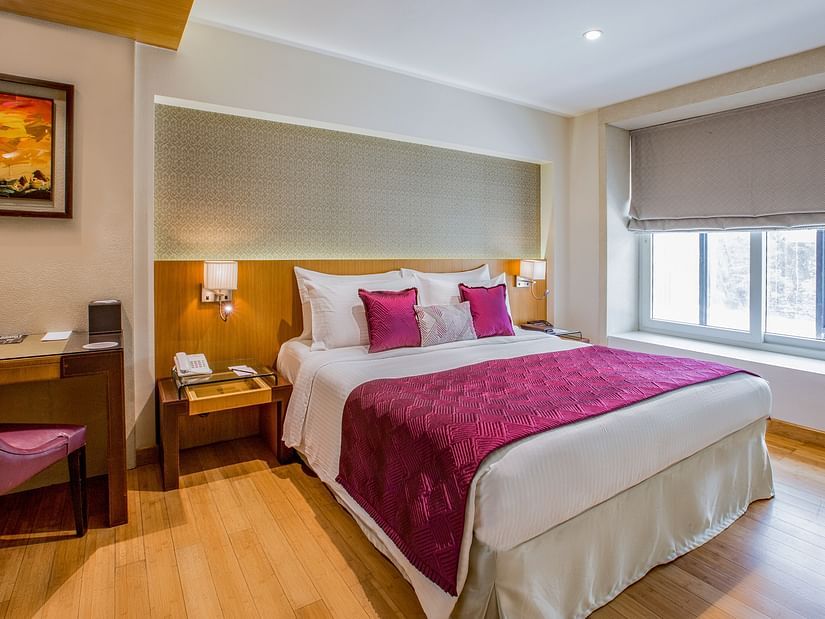 room with king size bed and wooden flooring at hotel bawa continental