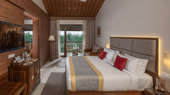A large bedroom of Raja Ravi Varma Suite with a king size bed and a wooden headboard at Uday Suites