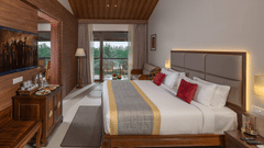 A large bedroom of Raja Ravi Varma Suite with a king size bed and a wooden headboard at Uday Suites