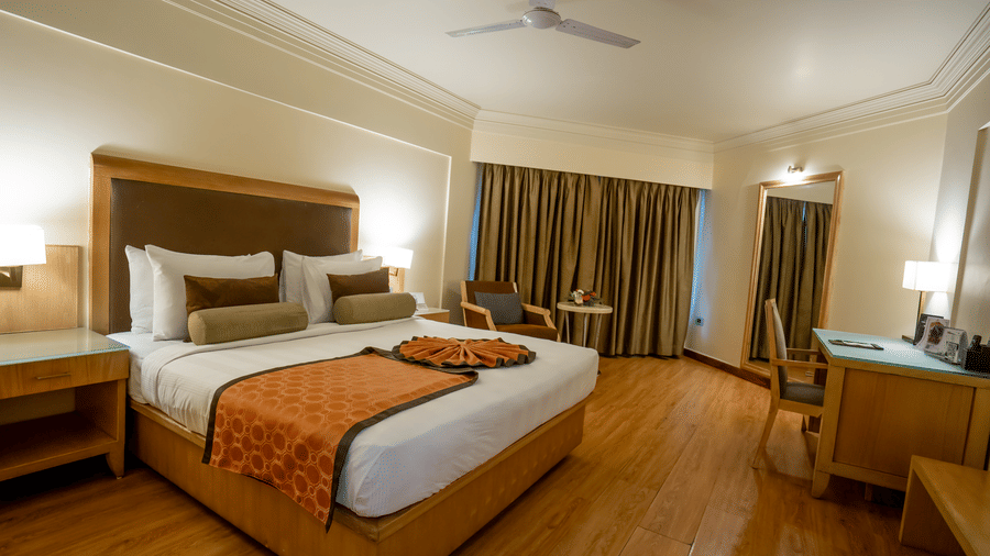 Well-appointed bedroom with breakfast tray setup and warm lighting at The Pride Premier Nagpur.
