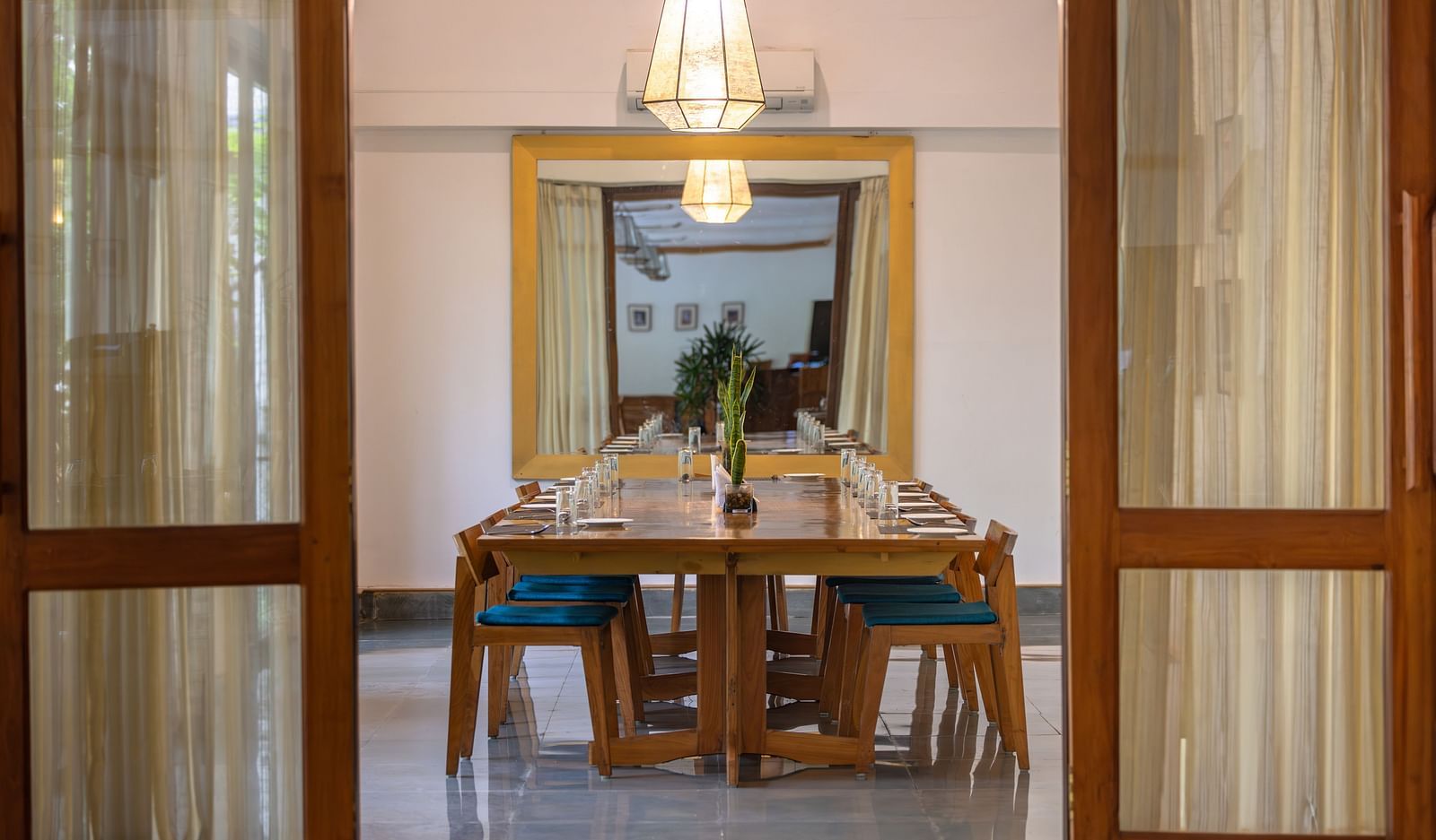 The boardroom at Saraca Resort & Spa Corbett with a large conference table arrangement in the centre and a chandelier hanging from the ceiling
