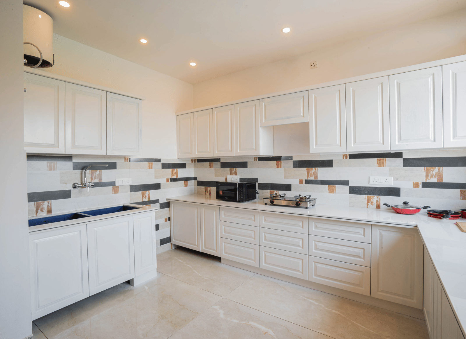 A kitchen with cabinets, tiled walls, and cooking appliances at Perfectstayz Value Paradise, Mussoorie.