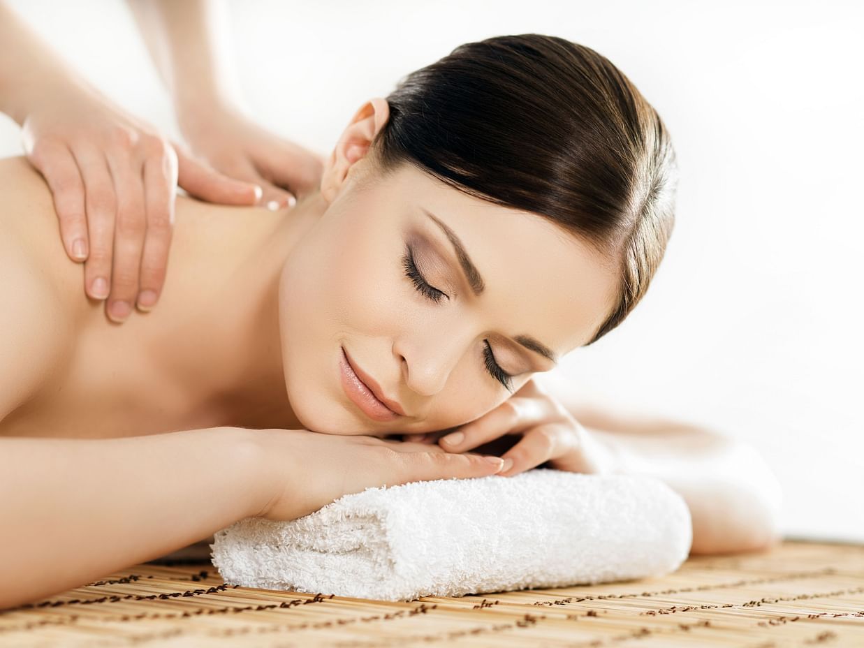 A woman resting her head on a towel and getting a massage 