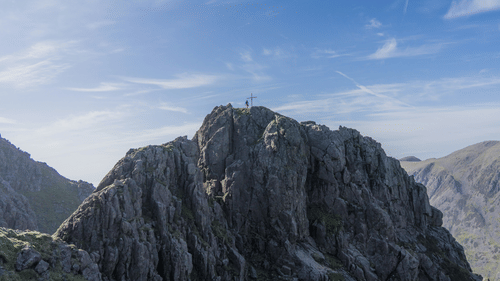 View of a hill with a blue sky and clouds in the background