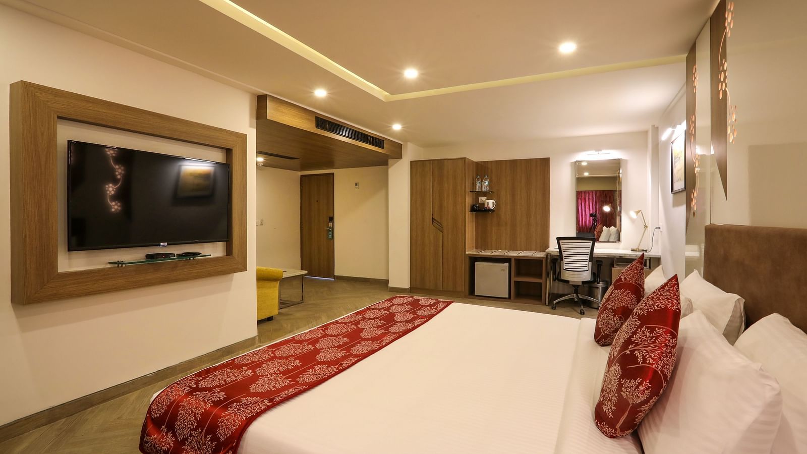 A large bedroom with a mounted television and a workdesk on the other end of the room - Mango Hill Central, Chennai