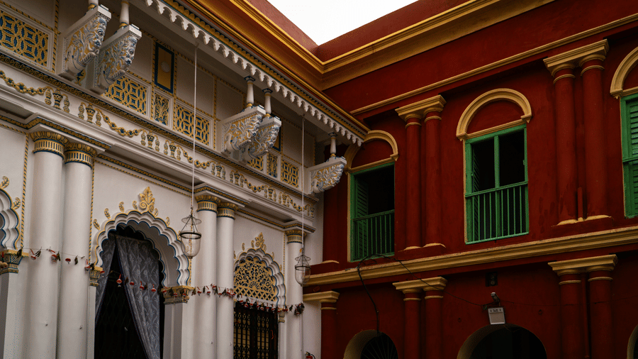 grand colonial courtyard featuring ornate white arches juxtaposed against deep red-and-yellow brick walls