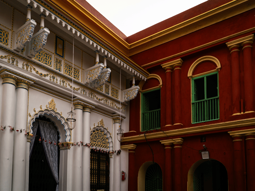 grand colonial courtyard featuring ornate white arches juxtaposed against deep red-and-yellow brick walls
