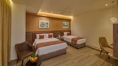 Our Family Rooms in Mysore offering a queen size and single bed along with furniture for a comfortable stay
