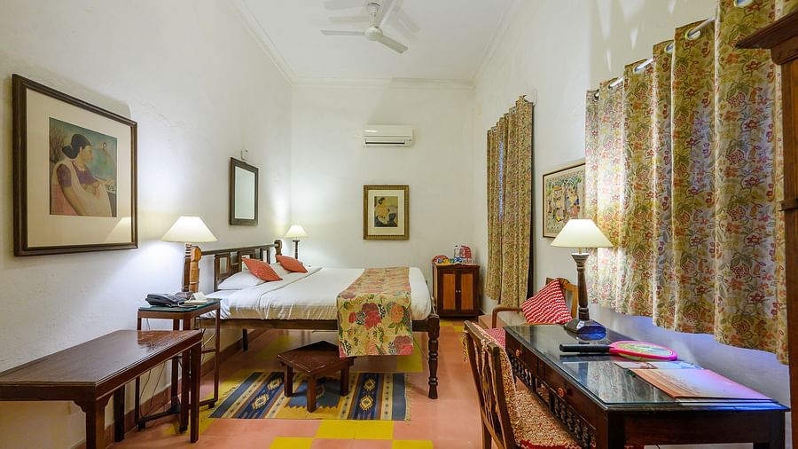Hill Fort Kesroli 14th Century Alwar - interior view of the Simurgh Mahal with brown curtains, king size bed and a wooden work desk