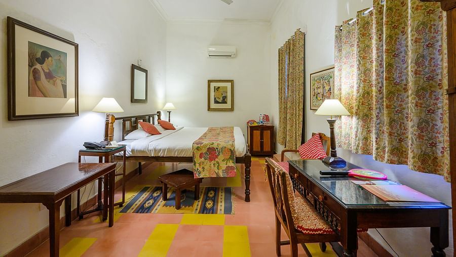 Hill Fort Kesroli 14th Century Alwar - interior view of the Simurgh Mahal with brown curtains, king size bed and a wooden work desk