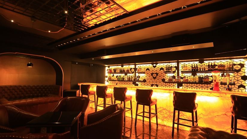 side view of the Bar Counter with a showcase in the background at Alchemy, our in-house bar in Chennai - Raj Park Hotel, Chennai