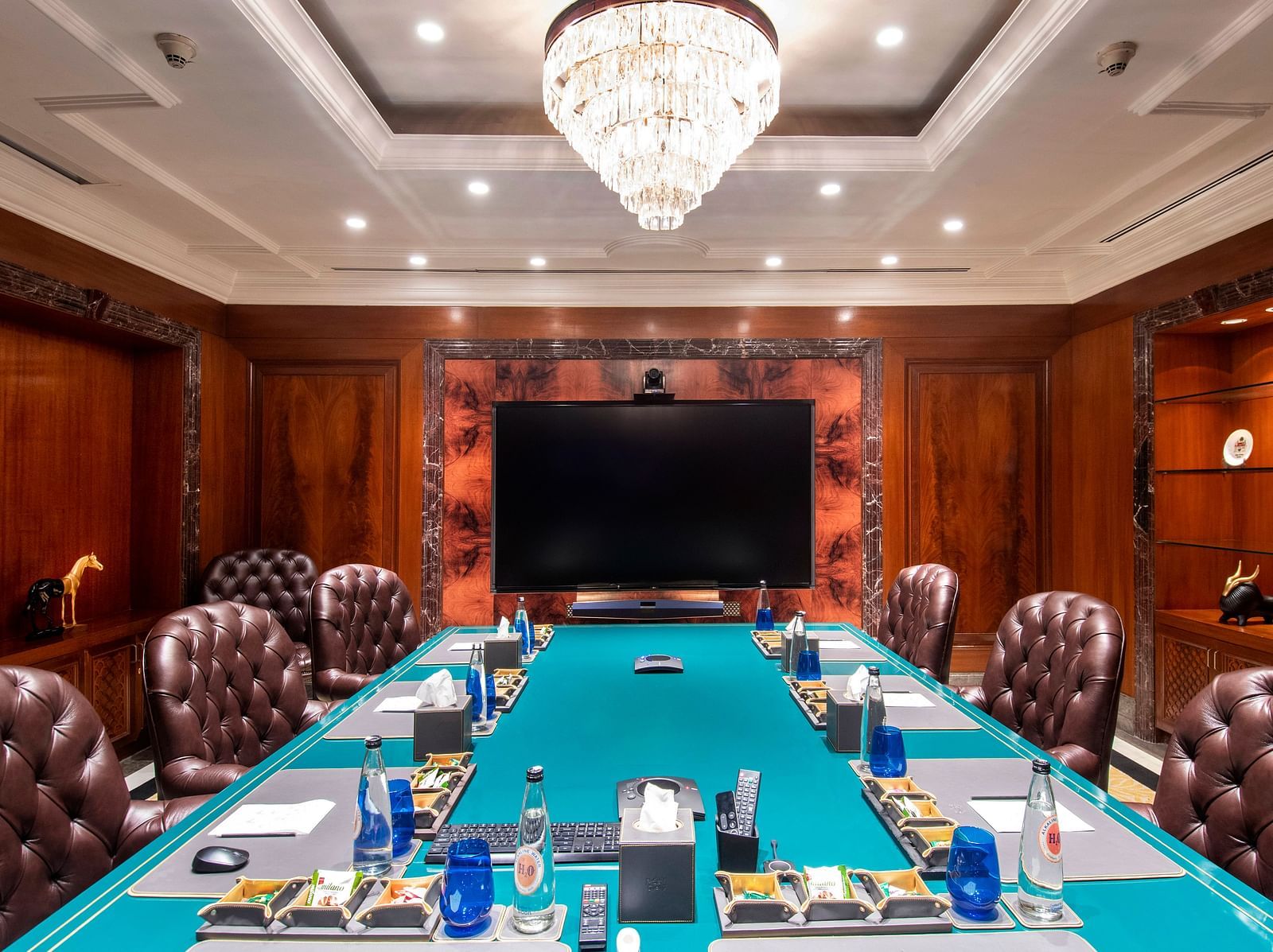 a full view of the senate boardroom at the claridges new delhi with a wall mounted tv screen at the far end of the room