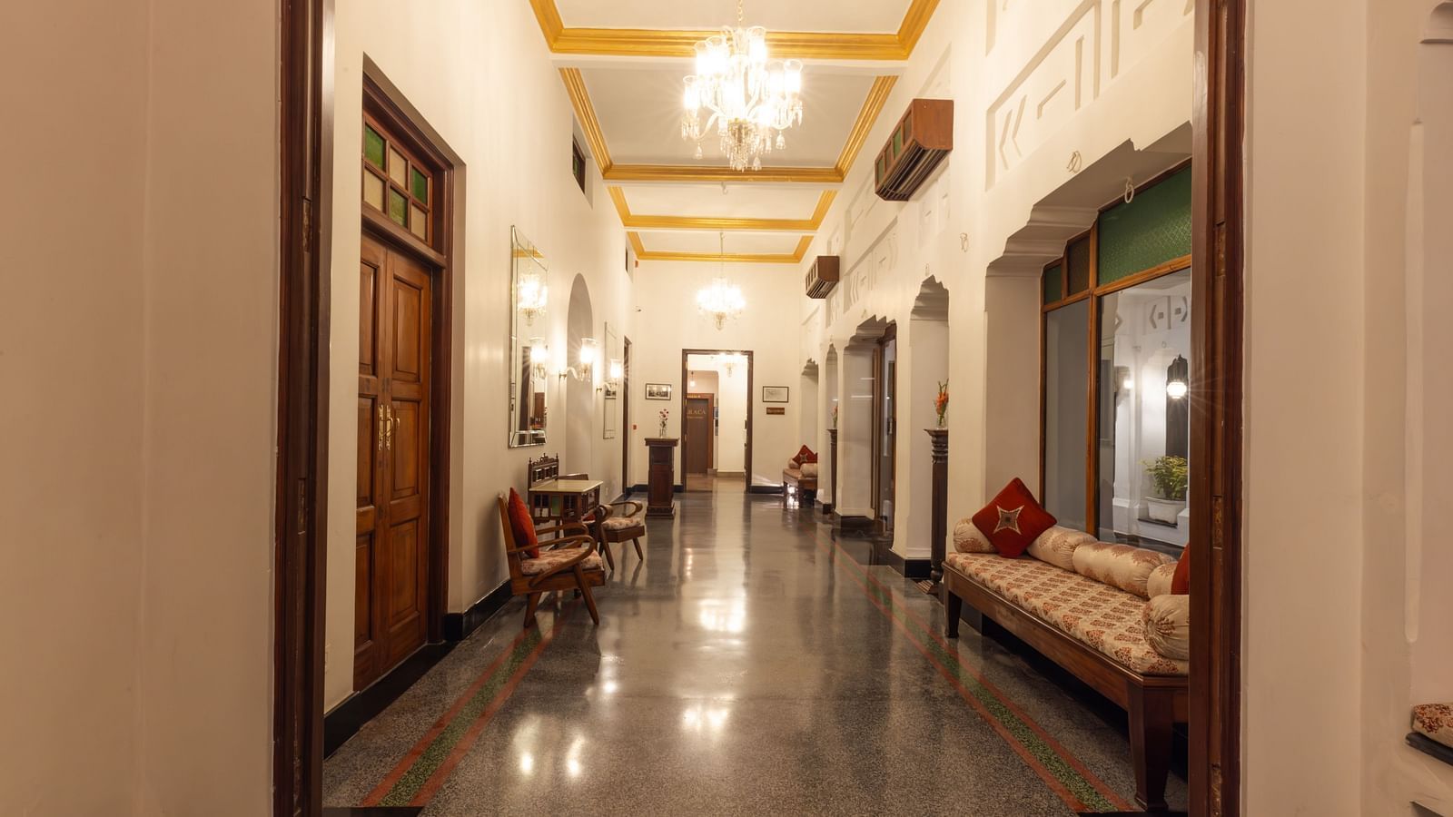 Lobby area of Saraca Hotel, Lucknow with tall ceilings and a chandelier hanging from the middle